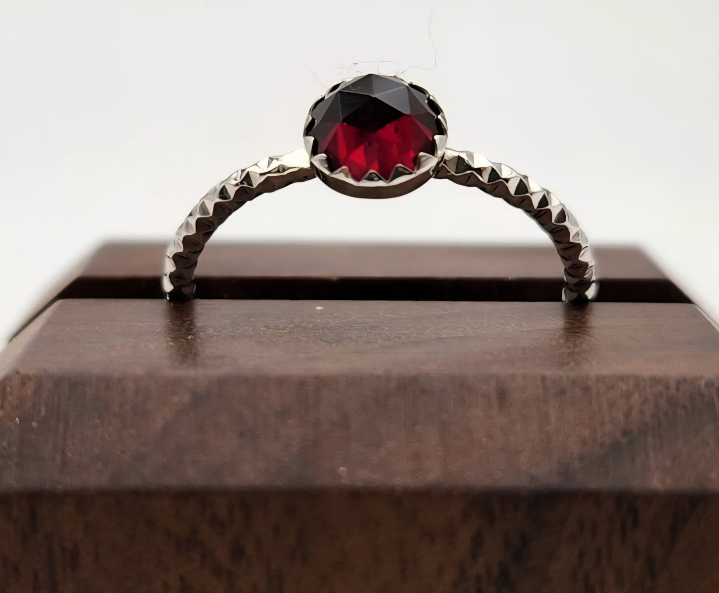 Ring with a red gemstone on a wooden surface