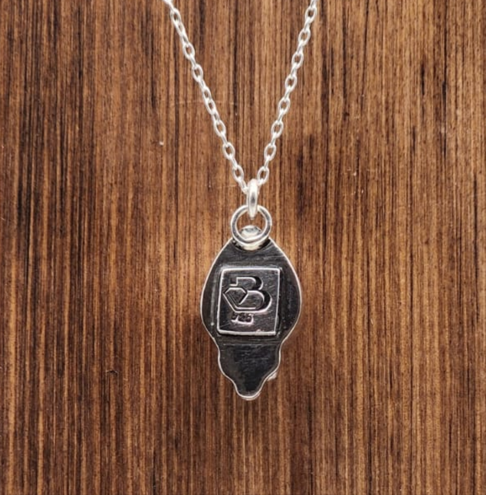 Silver necklace with a pendant on a wooden surface