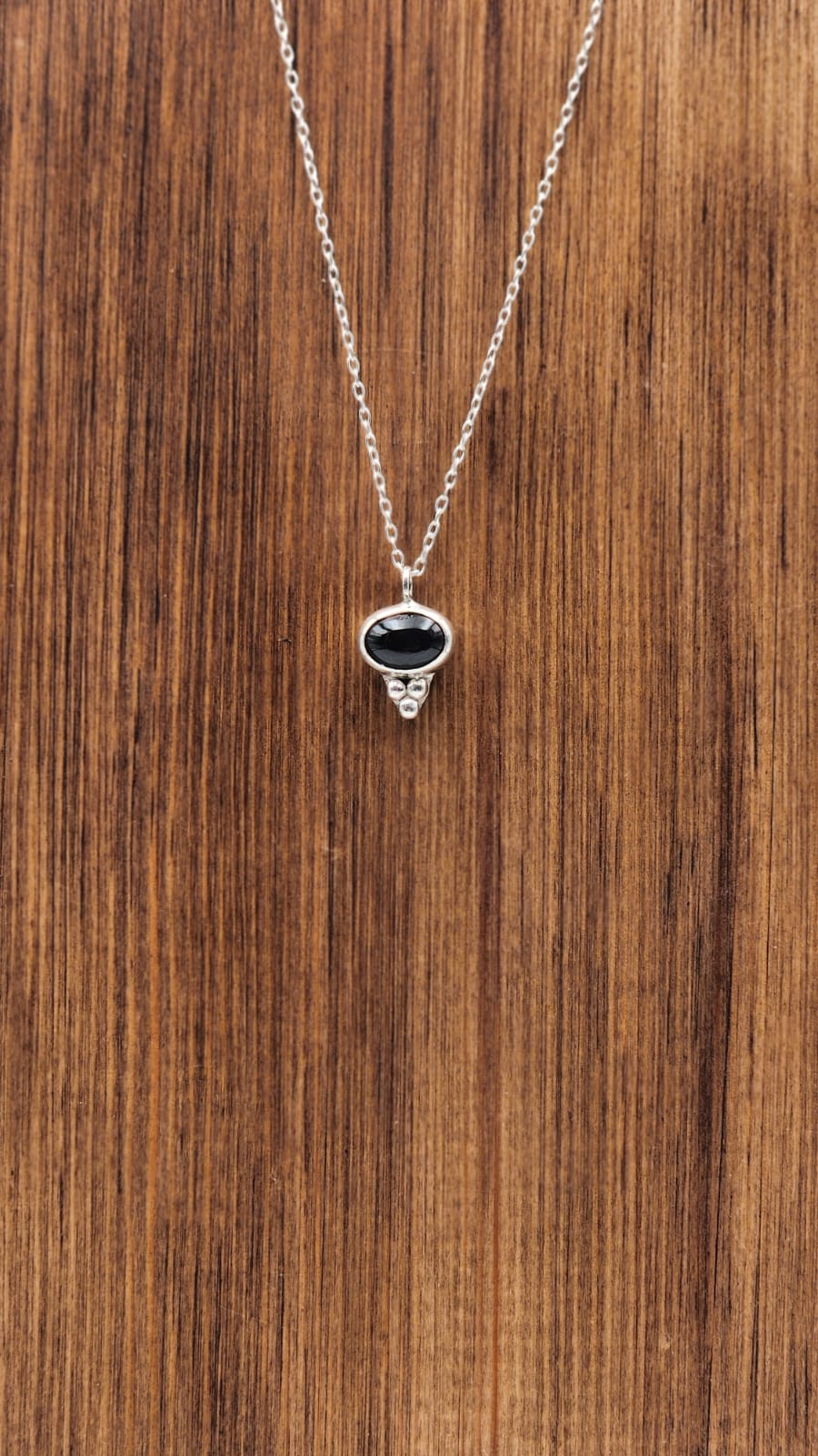 Necklace with a pendant on a wooden surface