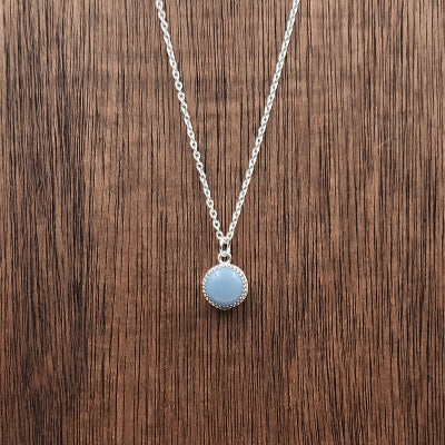 Small Sterling Silver Owyee Blue Opal Pendant on a Wooden Display