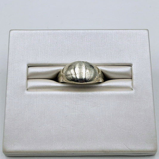 A silver ring with a textured, ribbed dome-shaped face, displayed in a white satin-lined presentation box.