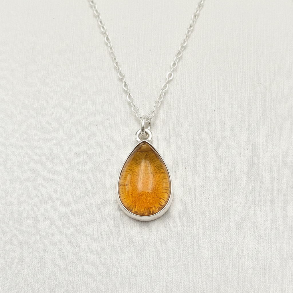 Ashes encased in glass in Handmade Sterling Silver teardrop pendant.