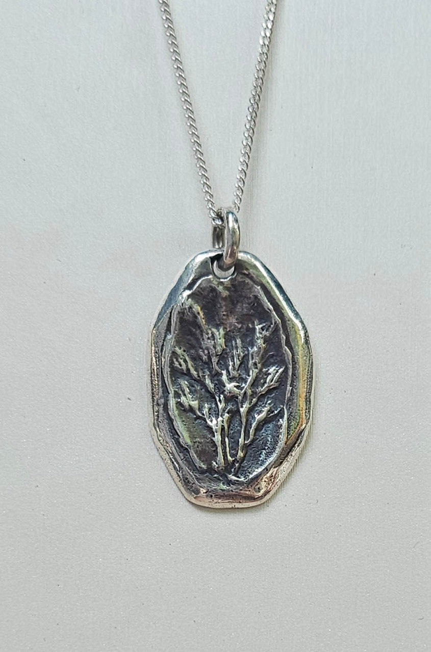 Silver pendant necklace on a light gray background