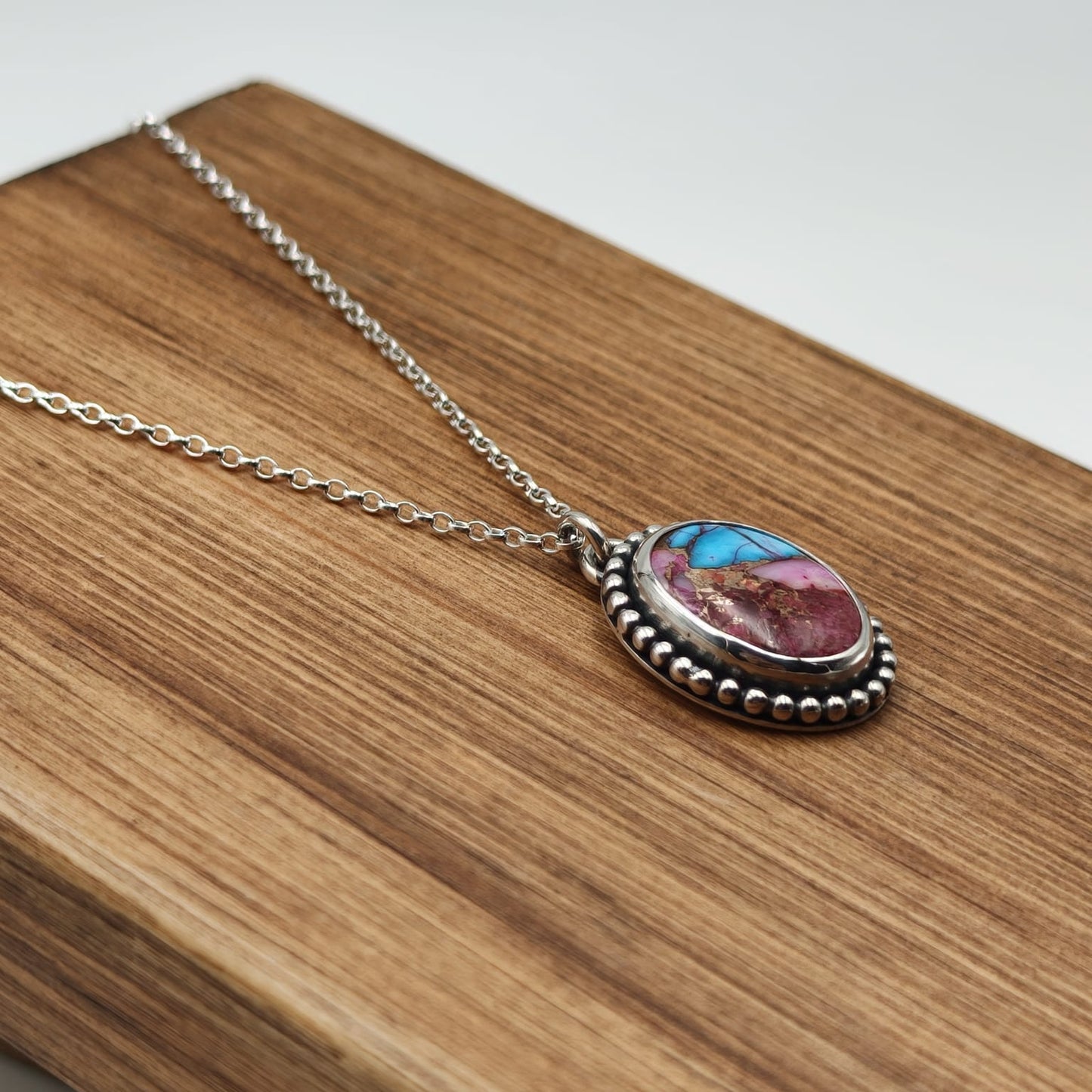 Necklace with a colorful pendant on a wooden surface