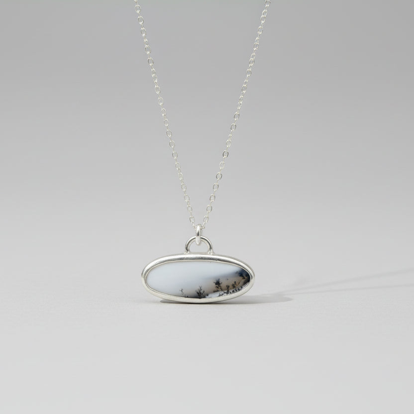 Sterling Silver and Dendritic Opal Oval scenic pendant on gray backdrop 