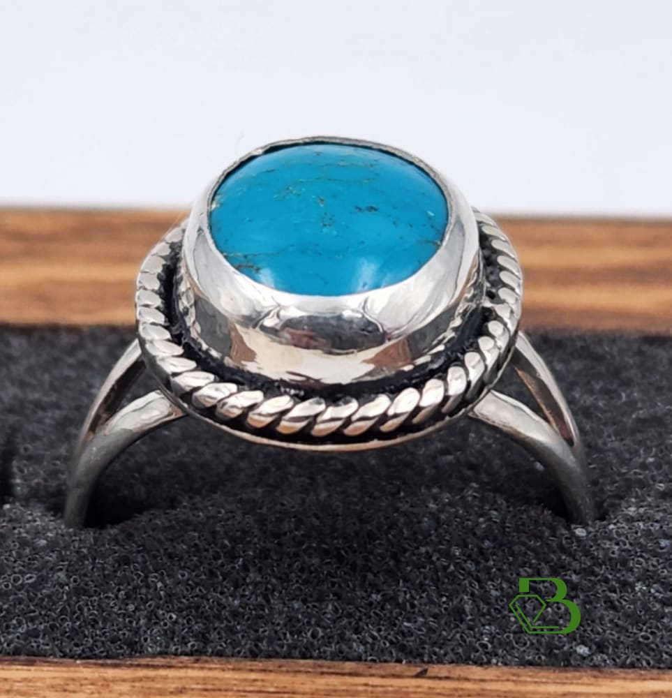 A Kingman Turquoise cabochon set in a sterling silver with rope feature and split ring shoulders 